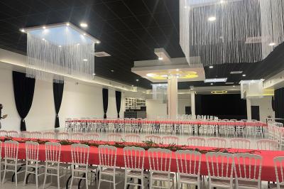 Deux roll-ups promotionnels et une table noire avec des boîtes en bois dans une salle lumineuse au sol blanc.