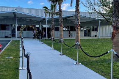 Deux roll-ups promotionnels et une table noire avec des boîtes en bois dans une salle lumineuse au sol blanc.