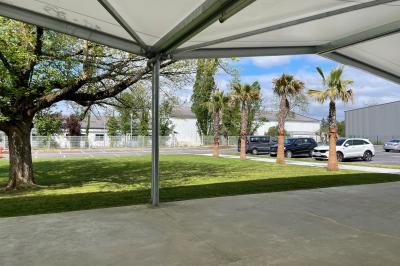 Deux roll-ups promotionnels et une table noire avec des boîtes en bois dans une salle lumineuse au sol blanc.