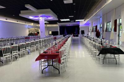 Deux roll-ups promotionnels et une table noire avec des boîtes en bois dans une salle lumineuse au sol blanc.