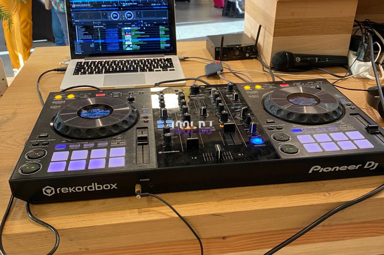 Table de mixage Pioneer DJ avec ordinateur portable ouvert, installée sur un comptoir en bois lors d'un événement.