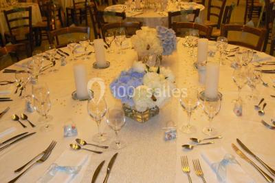 Deux bouteilles de vin, une blanche et une rouge, posées sur un tonneau en bois avec un fond de verdure.