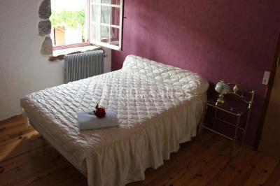 Deux bouteilles de vin, une blanche et une rouge, posées sur un tonneau en bois avec un fond de verdure.