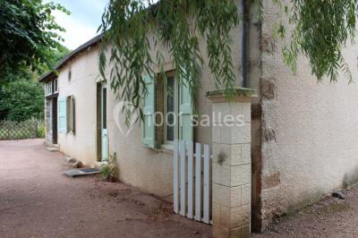 Deux bouteilles de vin, une blanche et une rouge, posées sur un tonneau en bois avec un fond de verdure.