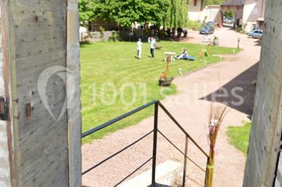 Deux bouteilles de vin, une blanche et une rouge, posées sur un tonneau en bois avec un fond de verdure.