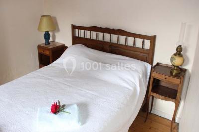 Deux bouteilles de vin, une blanche et une rouge, posées sur un tonneau en bois avec un fond de verdure.