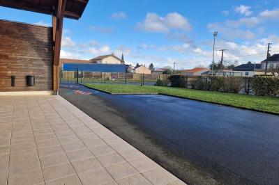 Salle de réception décorée avec des tables rondes, des chaises transparentes et des compositions florales roses et blanches.