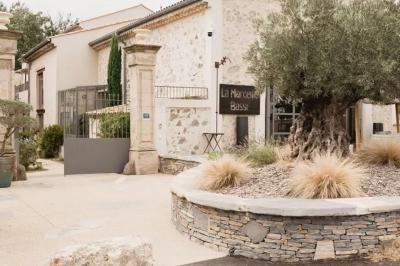 Terrasse aménagée pour un événement avec tables hautes drapées de noir, guirlandes lumineuses et végétation en arrière-plan.