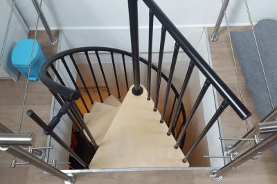 Salle de réunion avec tables noires, chaises, écran de projection, tableau blanc et éclairage naturel.