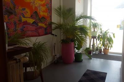 Salle de réunion avec tables noires, chaises, écran de projection, tableau blanc et éclairage naturel.