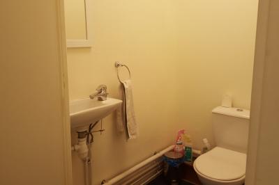 Salle de réunion avec tables noires, chaises, écran de projection, tableau blanc et éclairage naturel.