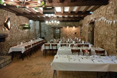 Cuisine professionnelle avec plans de travail en inox, réfrigérateur blanc, étagères murales et sol en carrelage.