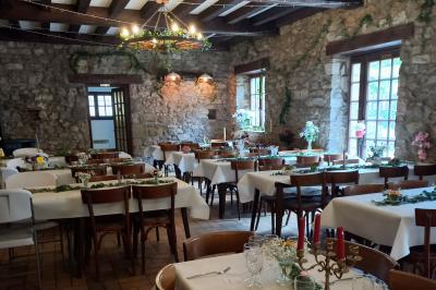 Cuisine professionnelle avec plans de travail en inox, réfrigérateur blanc, étagères murales et sol en carrelage.