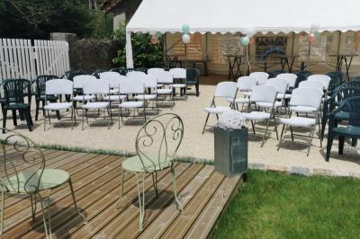 Cuisine professionnelle avec plans de travail en inox, réfrigérateur blanc, étagères murales et sol en carrelage.