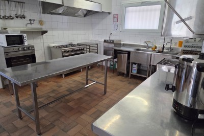 Salle de bain moderne avec douche à l'italienne, paroi vitrée, meuble vasque blanc et carrelage beige et marron.