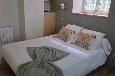 Salle de bain moderne avec douche à l'italienne, paroi vitrée, meuble vasque blanc et carrelage beige et marron.