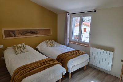 Salle de bain moderne avec douche à l'italienne, paroi vitrée, meuble vasque blanc et carrelage beige et marron.