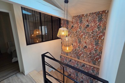 Salle de bain moderne avec douche à l'italienne, paroi vitrée, meuble vasque blanc et carrelage beige et marron.