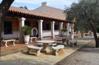 Une cavalière en tenue traditionnelle guide un cheval blanc dans une arène devant un public attentif.