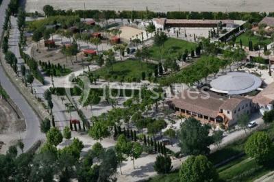 Une cavalière en tenue traditionnelle guide un cheval blanc dans une arène devant un public attentif.