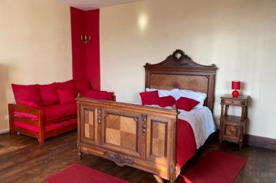 Échelle en bois décorée de bouteilles en verre marron, fleurs séchées et cadre sur fond de mur en pierre.