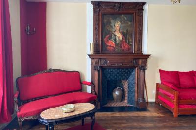 Échelle en bois décorée de bouteilles en verre marron, fleurs séchées et cadre sur fond de mur en pierre.