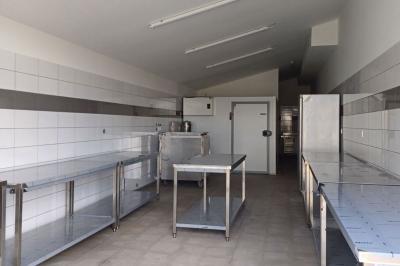 Échelle en bois décorée de bouteilles en verre marron, fleurs séchées et cadre sur fond de mur en pierre.