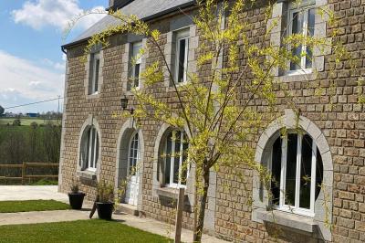 Échelle en bois décorée de bouteilles en verre marron, fleurs séchées et cadre sur fond de mur en pierre.