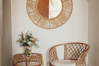 Échelle en bois décorée de bouteilles en verre marron, fleurs séchées et cadre sur fond de mur en pierre.