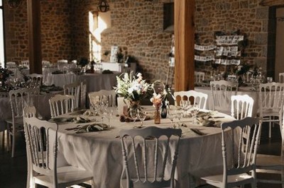 Échelle en bois décorée de bouteilles en verre marron, fleurs séchées et cadre sur fond de mur en pierre.