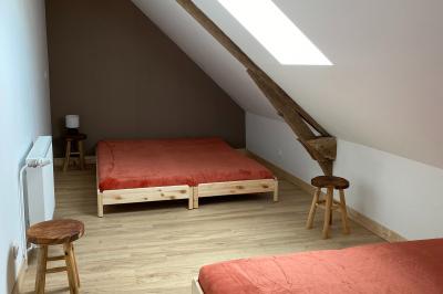 Échelle en bois décorée de bouteilles en verre marron, fleurs séchées et cadre sur fond de mur en pierre.