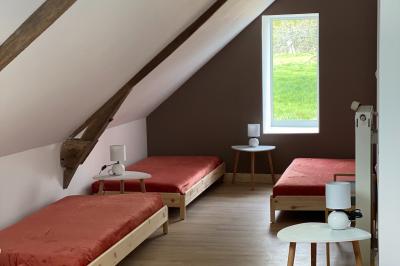 Échelle en bois décorée de bouteilles en verre marron, fleurs séchées et cadre sur fond de mur en pierre.