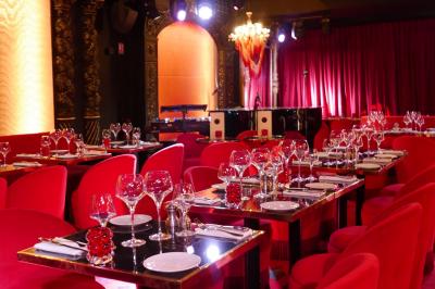 Quatre verres à vin alignés sur une table en marbre noir, avec un photophore rouge et des couverts à proximité.