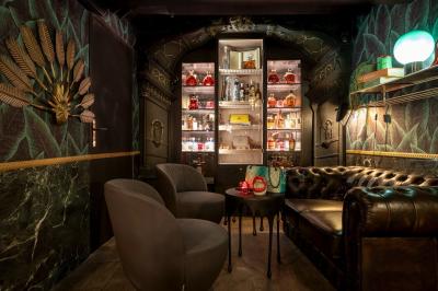 Quatre verres à vin alignés sur une table en marbre noir, avec un photophore rouge et des couverts à proximité.