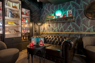 Quatre verres à vin alignés sur une table en marbre noir, avec un photophore rouge et des couverts à proximité.