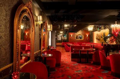 Quatre verres à vin alignés sur une table en marbre noir, avec un photophore rouge et des couverts à proximité.