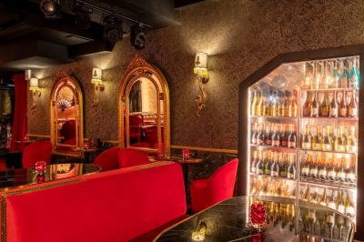 Quatre verres à vin alignés sur une table en marbre noir, avec un photophore rouge et des couverts à proximité.