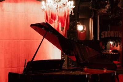 Quatre verres à vin alignés sur une table en marbre noir, avec un photophore rouge et des couverts à proximité.