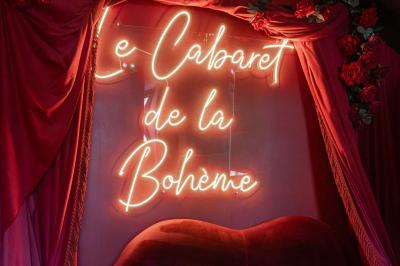 Quatre verres à vin alignés sur une table en marbre noir, avec un photophore rouge et des couverts à proximité.