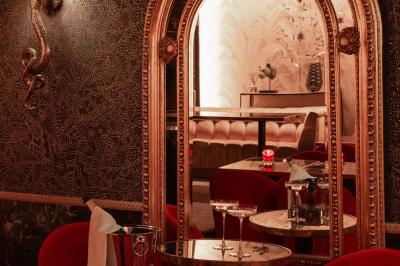 Quatre verres à vin alignés sur une table en marbre noir, avec un photophore rouge et des couverts à proximité.