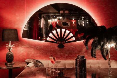 Quatre verres à vin alignés sur une table en marbre noir, avec un photophore rouge et des couverts à proximité.