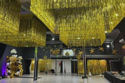 Salle de détente avec fauteuils variés, table basse, tapis géométrique et éclairage tamisé.