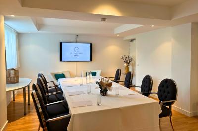 Piscine intérieure lumineuse avec grandes baies vitrées, entourée de chaises longues et de plantes décoratives.