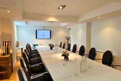 Piscine intérieure lumineuse avec grandes baies vitrées, entourée de chaises longues et de plantes décoratives.