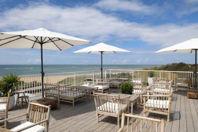 Piscine intérieure lumineuse avec grandes baies vitrées, entourée de chaises longues et de plantes décoratives.