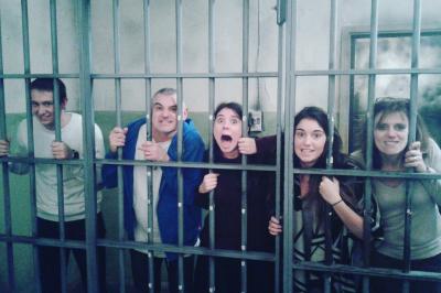 Deux femmes observent un élément lumineux dans un décor naturel avec des plantes et des rochers roses.