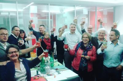 Deux femmes observent un élément lumineux dans un décor naturel avec des plantes et des rochers roses.