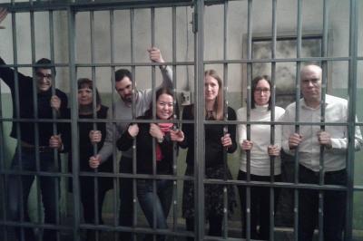 Deux femmes observent un élément lumineux dans un décor naturel avec des plantes et des rochers roses.