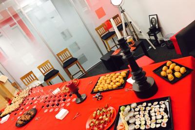 Deux femmes observent un élément lumineux dans un décor naturel avec des plantes et des rochers roses.