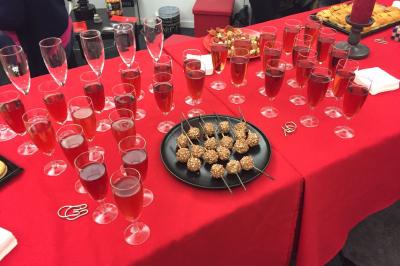 Deux femmes observent un élément lumineux dans un décor naturel avec des plantes et des rochers roses.